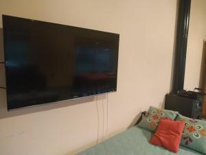 a flat screen tv hanging on a wall with a couch at LA QUINTA DE LOLI in San Pedro