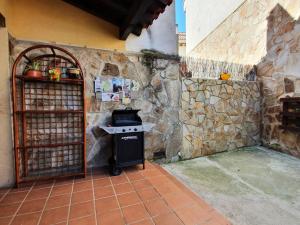 cocina con fogones y pared de piedra en Casa rural en la Sierra Norte de Madrid, en Manjirón