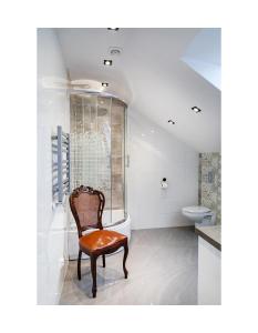 - une chaise dans la salle de bains pourvue d'une baignoire et de toilettes dans l'établissement Apartament Kornelia, à Gołdap