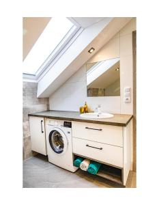 a bathroom with a sink and a washing machine at Apartament Kornelia in Gołdap