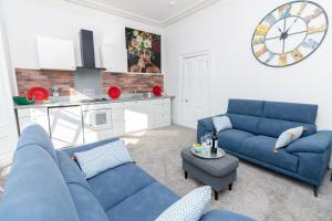 a living room with blue couches and a clock at Bridgeview in Dundee