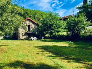 une maison en pierre dans un champ avec une grande cour dans l'établissement Domaine de BOURBACOUP, à Tulle