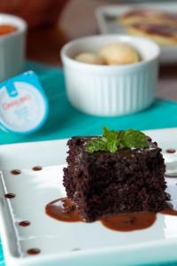 a piece of chocolate cake on a white plate at Pousada Algodão da Praia in Araruama