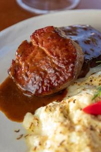 a plate of food with meat and eggs and sauce at Pousada Algodão da Praia in Araruama