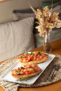 two pizzas on a white plate on a table at Pousada Algodão da Praia in Araruama
