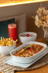 a table with a bowl of food and french fries at Pousada Algodão da Praia in Araruama