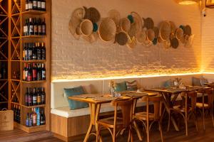 a restaurant with tables and chairs and a wall with wine glasses at Pousada Algodão da Praia in Araruama