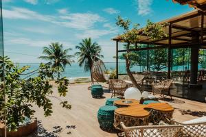 a patio with a table and chairs and the ocean at Pousada Algodão da Praia in Araruama