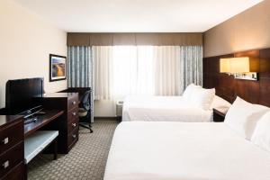 a hotel room with two beds and a flat screen tv at Rodd Royalty in Charlottetown