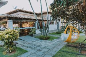 a swing in front of a house at Pousada Algodão da Praia in Araruama