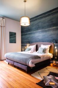 波尔多Volubilis Luxury Guest House的卧室里有一张大床，墙壁是蓝色的