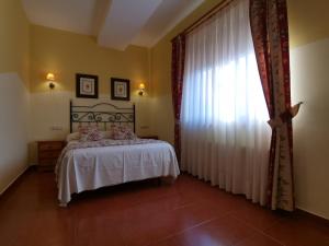 1 dormitorio con cama y ventana grande en Hotel El Angliru, en Soto de Cangas