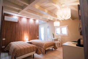 1 dormitorio con 2 camas, mesa y escritorio en Grantò B&B, en Gravina in Puglia