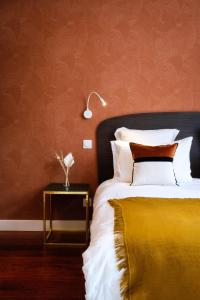 a bedroom with a bed and a table with a lamp at Volubilis Luxury Guest House in Bordeaux