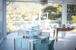una sala da pranzo con tavoli e sedie bianchi su un portico di Gaia e Levante a Piazza