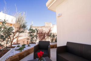 a patio with two chairs and a table with flowers on it at Grantò B&B in Gravina in Puglia