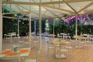 a banquet hall with tables and chairs and purple flowers at Vascellero Club Resort in Cariati