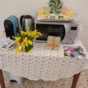 a table with a microwave and flowers on it at camera matrimoniale centro storico Galatina in Galatina