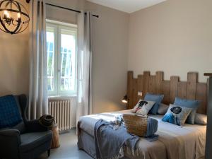 a bedroom with a bed and a chair and a window at Amatacasa Villa Rosa in Melfi