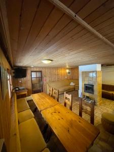 a large room with a wooden table and a bed at Chata Matičiar in Martin