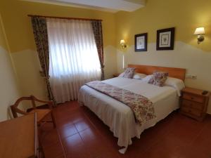 een slaapkamer met een groot bed en een raam bij Hotel El Angliru in Soto de Cangas