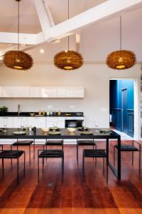 Volubilis Luxury Guest House في بوردو: مطبخ مع طاولة سوداء كبيرة وكراسي