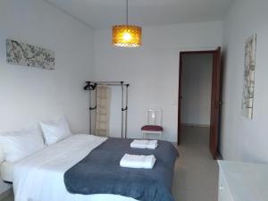 a bedroom with a bed with two towels on it at Casa do MIGUEL- 2 BEDROOM APARTMENT in Faro