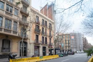 a city street with tall buildings and a yellow fence at Barcelona Eixample in Barcelona