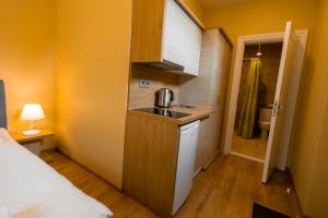 
a kitchen with a white sink and a white refrigerator at Palanga Camping Compensa Hotel in Palanga
