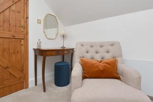Kirk Ireton的住宿－Briar Cottage，一张椅子,上面有橙色枕头,坐在桌子旁
