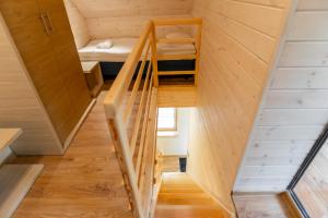 
a wooden staircase leading up to a room with a wooden floor at Palanga Camping Compensa Hotel in Palanga
