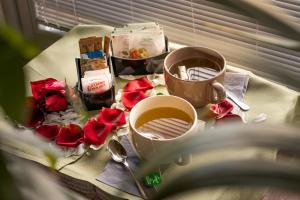 a table with two cups of coffee and roses at Chimera Tuscany Resort in Arezzo