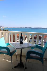 uma mesa com uma garrafa de vinho na varanda em Apartments Renata em Trogir