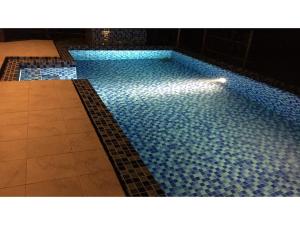 uma grande piscina com azulejos azuis no chão em Miyakojima Kurima Resort Seawood Hotel - Vacation STAY 16235v em Uechi