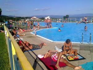 a group of people laying around a swimming pool at Apartmány Vihorlat II in Kaluža