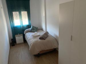 - une petite chambre avec un lit et une fenêtre dans l'établissement La Casa de Pablo, à Cenes de la Vega