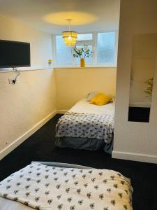 a bedroom with a bed and a window and a tv at Victoria Gardens in Sunderland