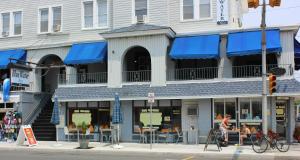 un bâtiment avec des auvents bleus dans une rue de la ville dans l'établissement Blue Water Inn, à Ocean City