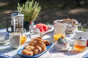 a table topped with plates of pastries and orange juice at Villa Dafnies in Ágios Prokópios