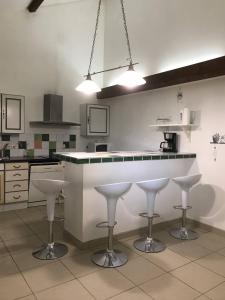 a kitchen with a counter and stools in it at Le Tâcheron in Saint-Sernin-du-Plain