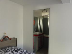 sypialnia z lustrem, umywalką i łóżkiem w obiekcie LIO w mieście Le Mans