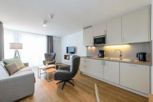 eine Küche und ein Wohnzimmer mit einem Sofa und einem Tisch in der Unterkunft Apartmentvilla Anna See Apartmentvilla Anna See 1-11 in Langeoog