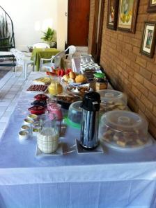 stół z niebieską tkaniną i jedzeniem w obiekcie Pousada Villa Joia w mieście Barra de São Miguel