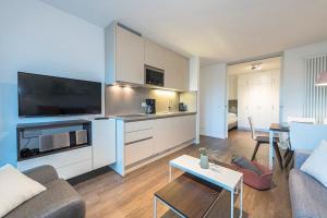 a living room with a couch and a kitchen with a table at Apartmentvilla Anna See Apartmentvilla Anna See 2-12 in Langeoog +8 photos