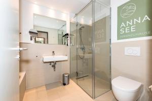 a bathroom with a shower and a toilet and a sink at Apartmentvilla Anna See Apartmentvilla Anna See 1-17 in Langeoog +9 photos
