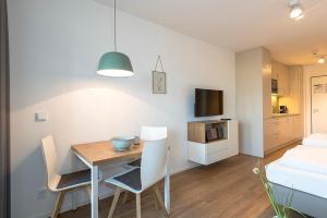 a room with a table and chairs and a bedroom at Apartmentvilla Anna See Apartmentvilla Anna See 2-14 in Langeoog