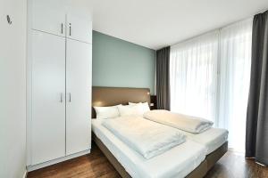 ein Schlafzimmer mit einem weißen Bett und einem großen Fenster in der Unterkunft Deichhäuser Anna Küste Deichhäuser Anna Küste 4-13 in Bensersiel + 15 Fotos