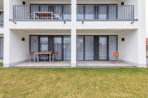 ein Haus mit einer Terrasse mit Tisch und Stühlen in der Unterkunft Deichhäuser Anna Küste Deichhäuser Anna Küste 4-13 in Bensersiel