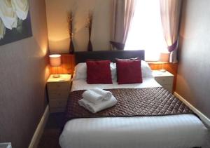 黑潭的住宿－the cumbrian hotel，一间卧室配有一张床,上面有两条毛巾