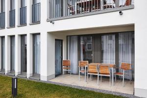 eine Gruppe von Stühlen und ein Tisch auf einer Terrasse in der Unterkunft Deichhäuser Anna Küste Deichhäuser Anna Küste 4-14 in Bensersiel